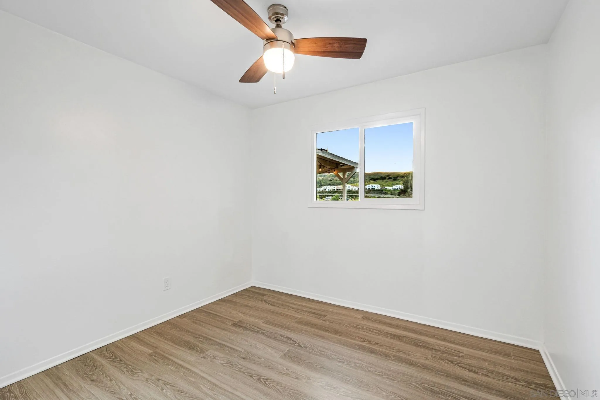 10330 Strathmore Drive Santee, CA 92071 - Photo 12 of 21 an empty room with a window and wooden floor