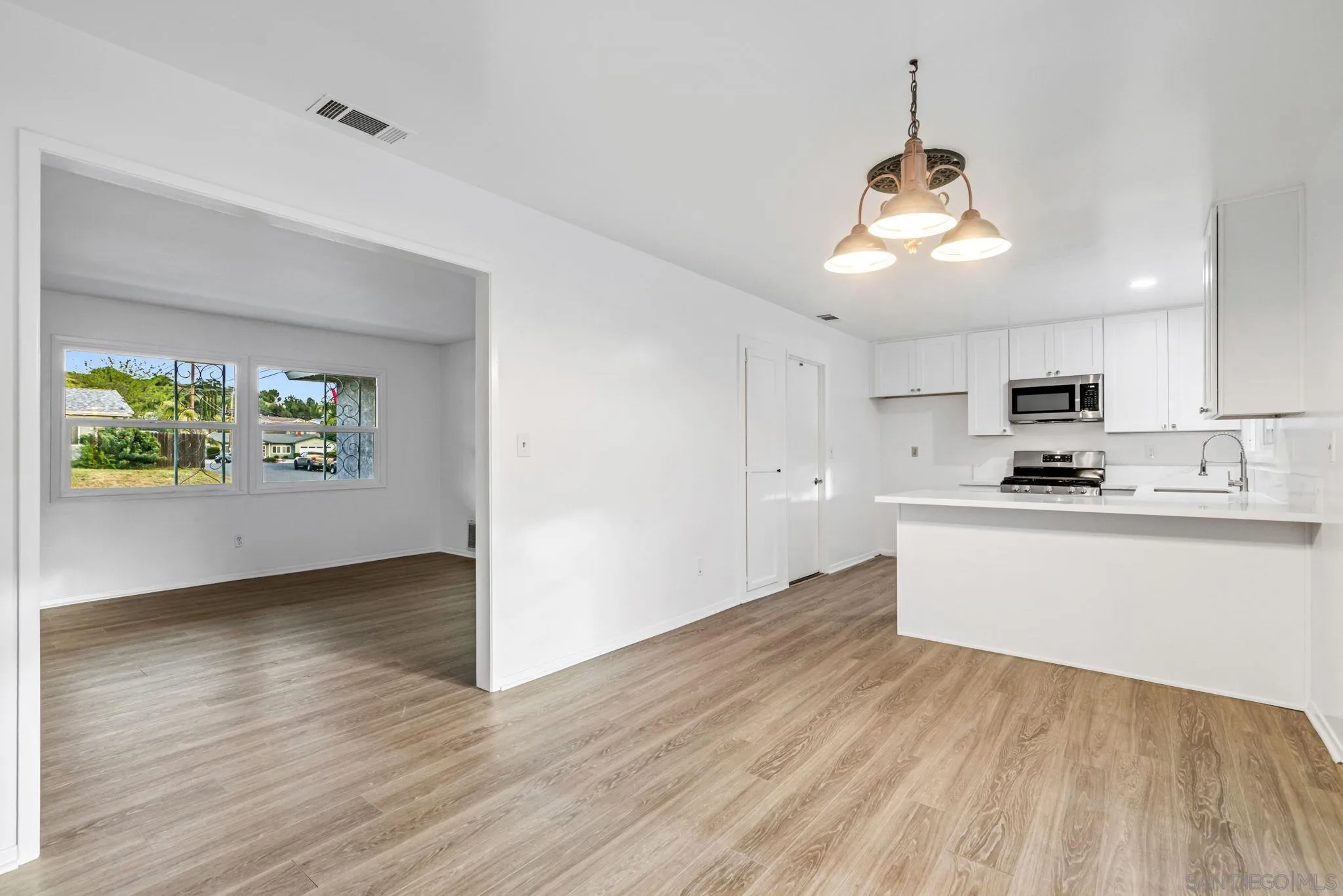 10330 Strathmore Drive Santee, CA 92071 - Photo 4 of 21 a view of kitchen with stainless steel appliances granite countertop a stove a sink and a wooden floors