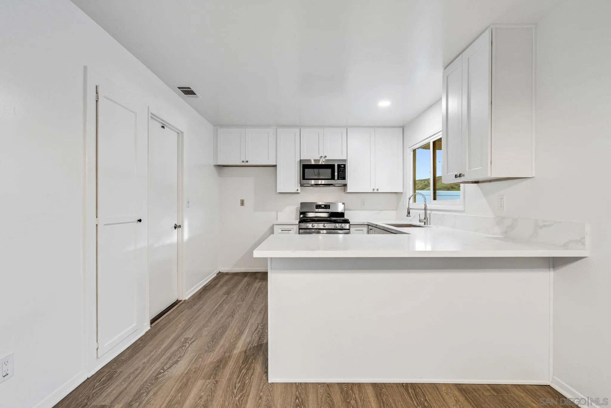 10330 Strathmore Drive Santee, CA 92071 - Photo 6 of 21 a kitchen with stainless steel appliances granite countertop a sink a stove a refrigerator and cabinets