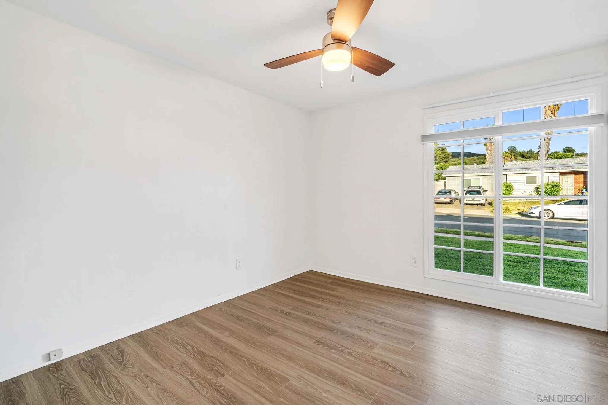 10330 Strathmore Drive Santee, CA 92071 - Photo 8 of 21 an empty room with wooden floor and windows