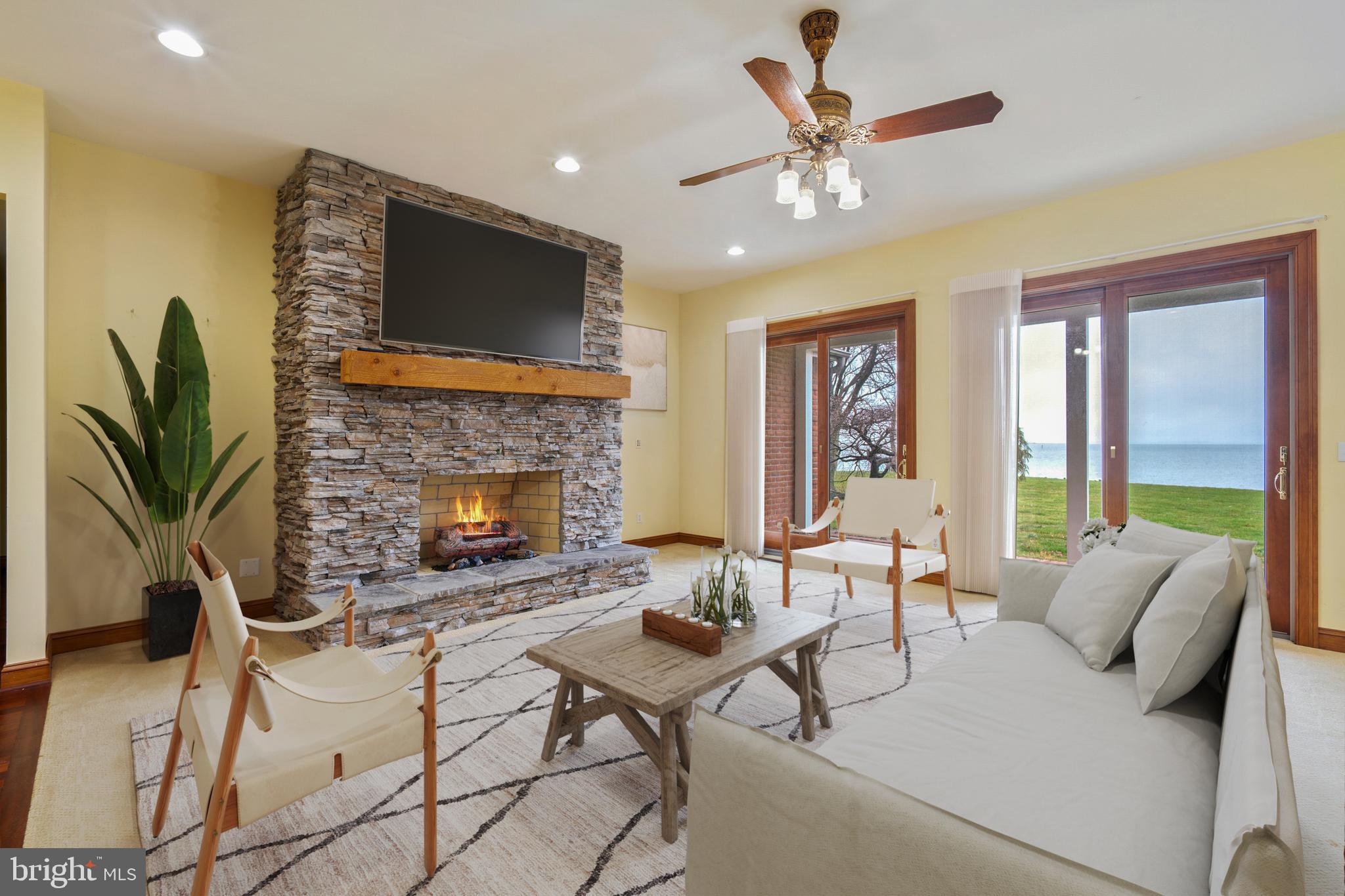 2817 Cox Neck Road Chester, MD 21619 - Photo 13 of 35 a living room with furniture a table and a fireplace