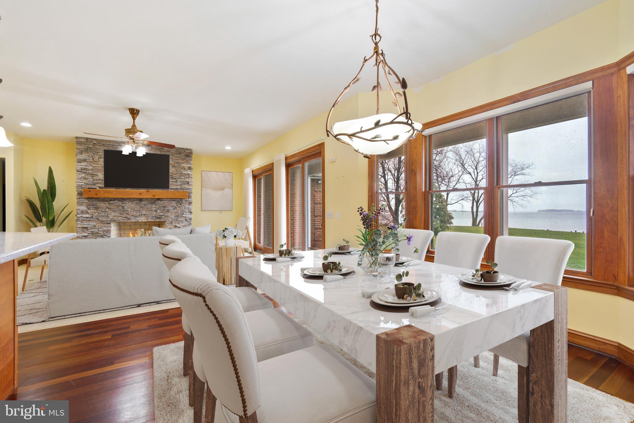 2817 Cox Neck Road Chester, MD 21619 - Photo 15 of 35 a dining room with wooden floor and large windows