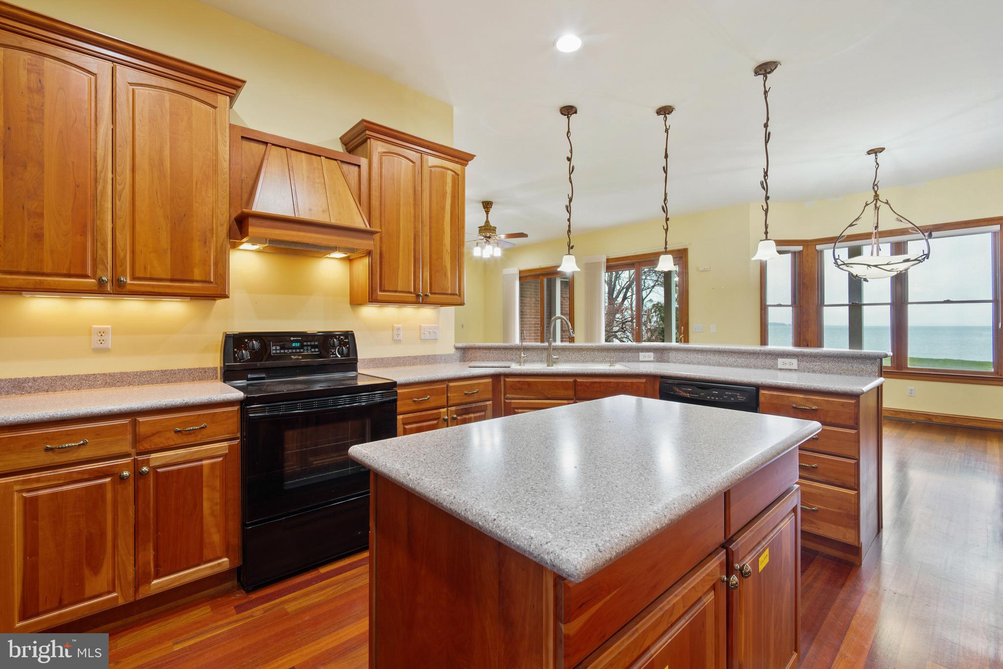 2817 Cox Neck Road Chester, MD 21619 - Photo 17 of 35 a kitchen with stainless steel appliances granite countertop a sink a stove and a wooden floors