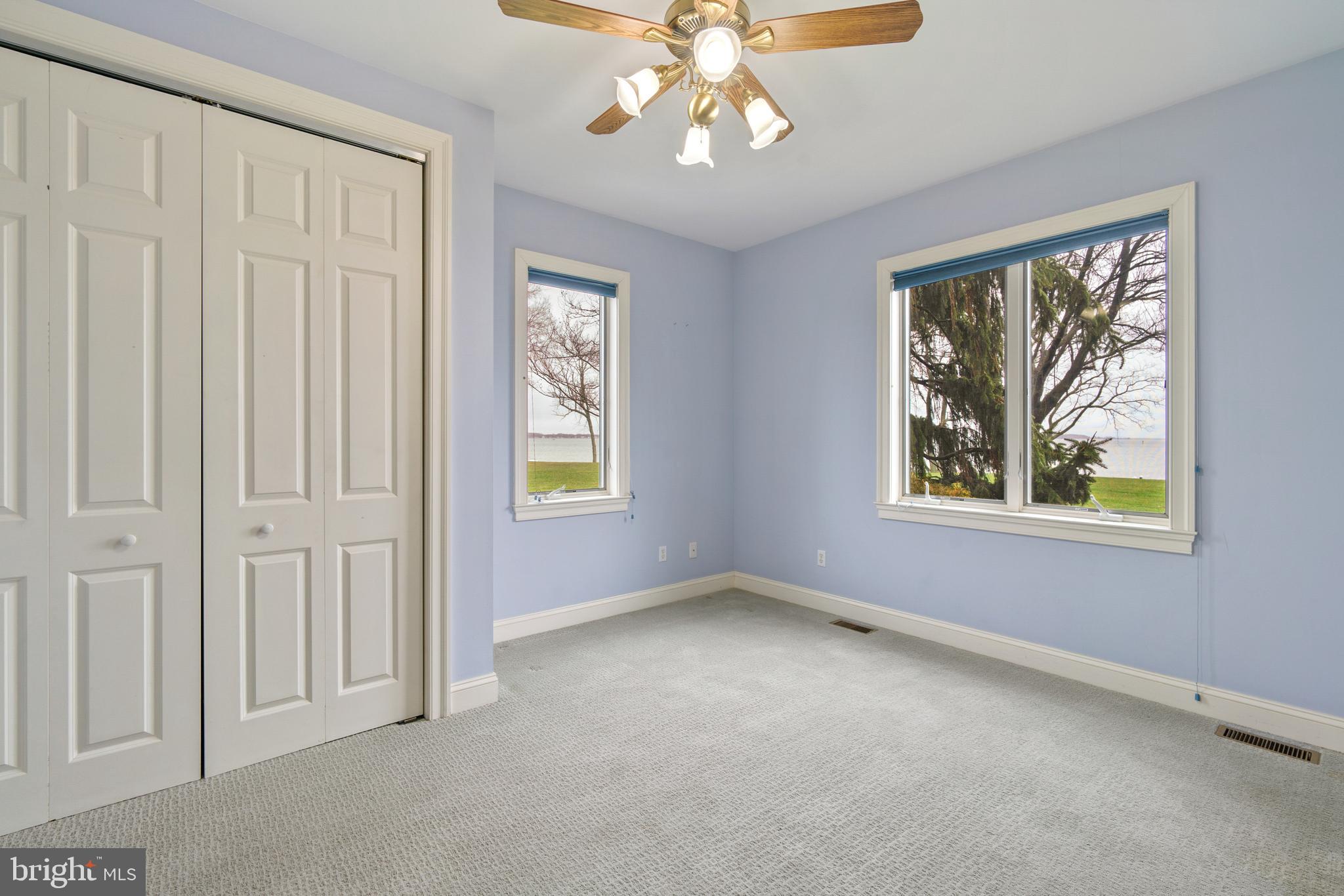 2817 Cox Neck Road Chester, MD 21619 - Photo 26 of 35 an empty room with windows and chandelier fan