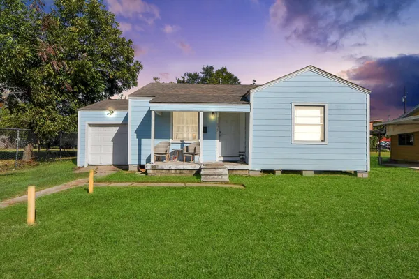 a view of a house with backyard and sitting area