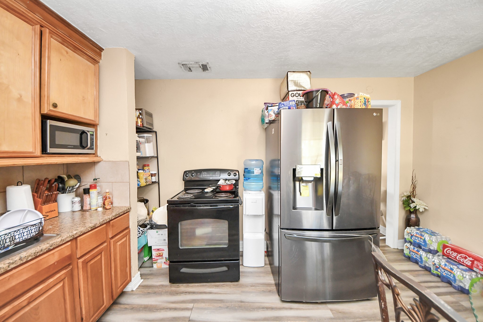11025 Muscatine Street Houston, TX 77029 - Photo 9 of 33 a kitchen with a refrigerator and a stove top oven