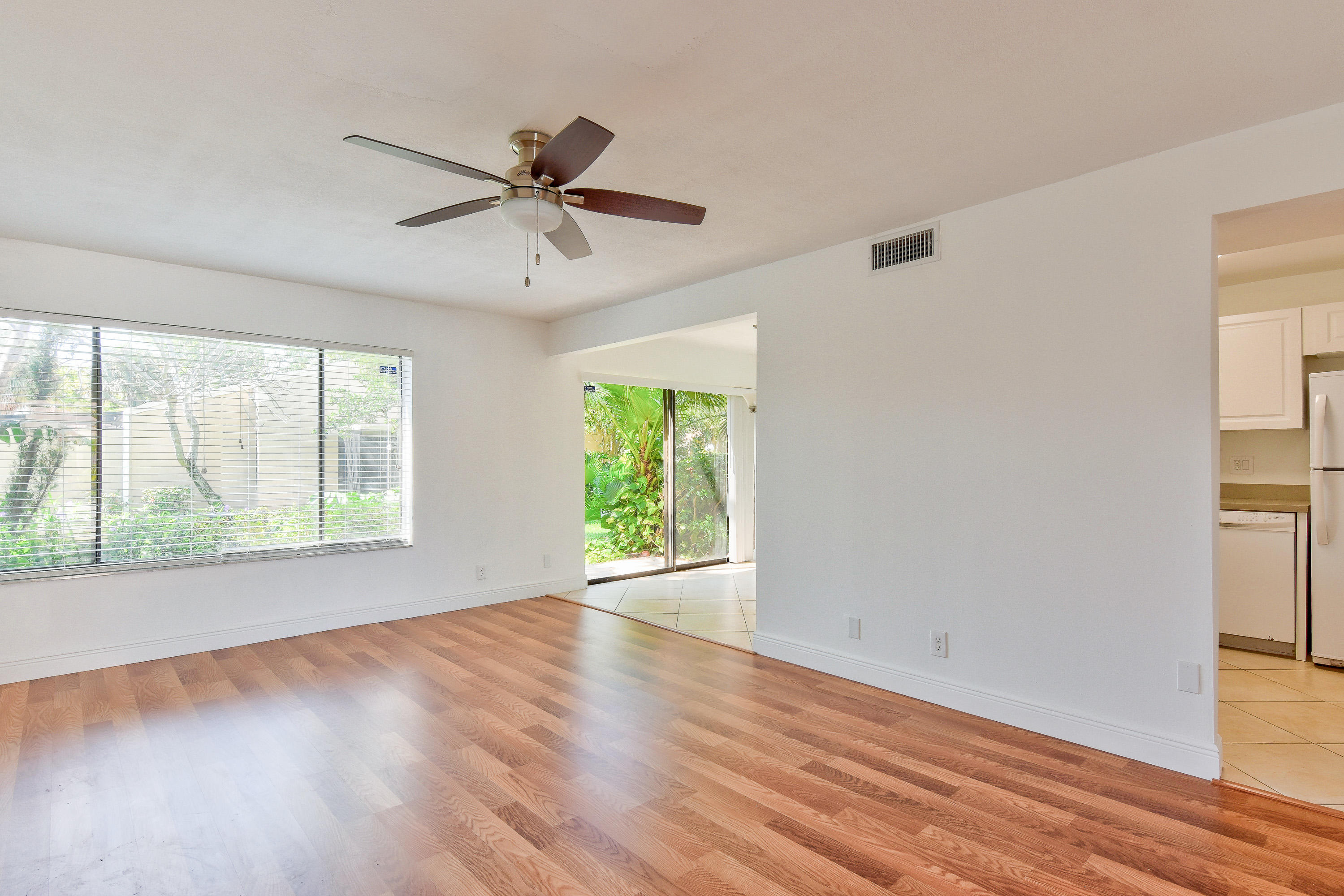 1149 Northwest 13th Street, Unit 7 Boca Raton, FL 33486 - Photo 3 of 14 a view of an empty room with wooden floor and a window