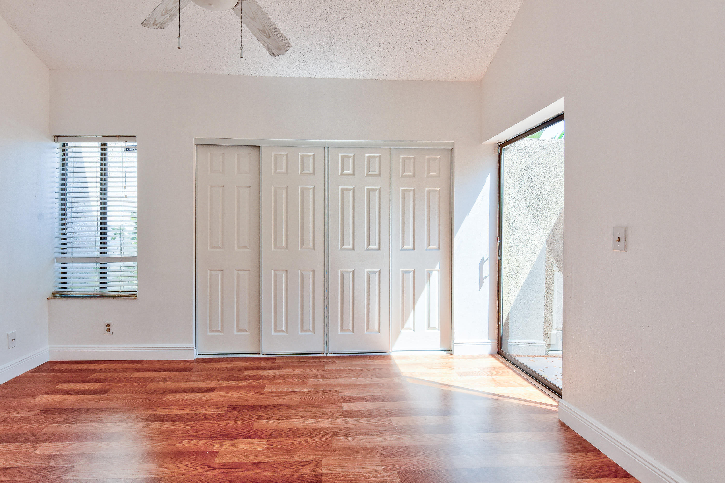 1149 Northwest 13th Street, Unit 7 Boca Raton, FL 33486 - Photo 8 of 14 an empty room with wooden floor and windows