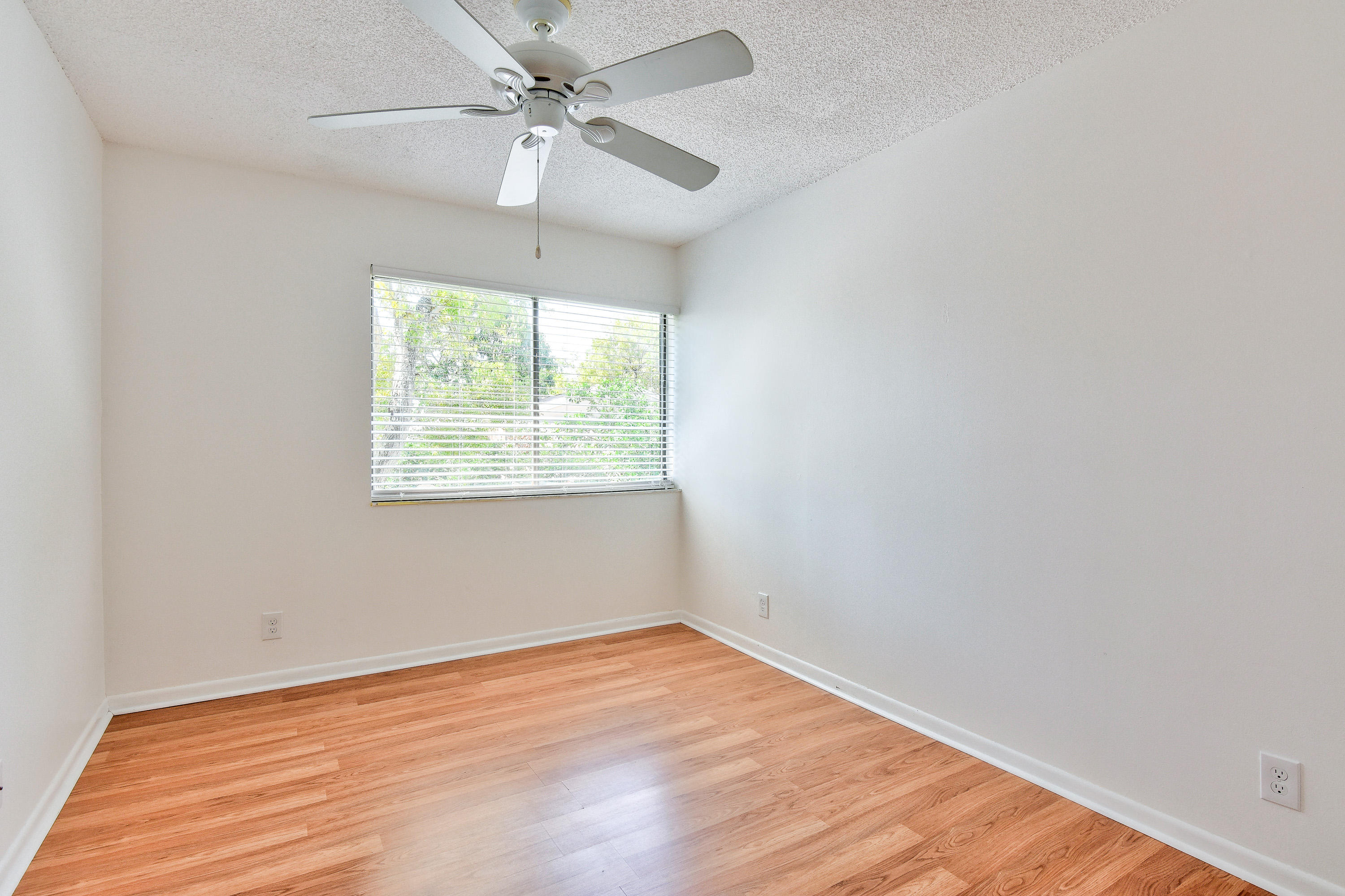 1149 Northwest 13th Street, Unit 7 Boca Raton, FL 33486 - Photo 10 of 14 an empty room with a window and a ceiling fan