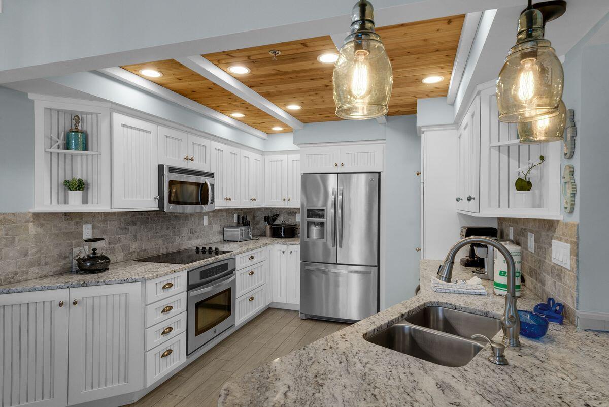 10254 East County Road, Unit 315 Inlet Beach, FL 32461 - Photo 3 of 37 a kitchen that has a lot of white cabinets and stainless steel appliances