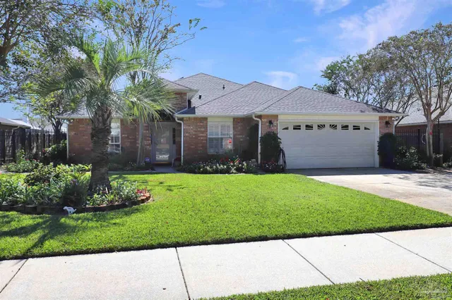a view of a house with backyard and sitting area