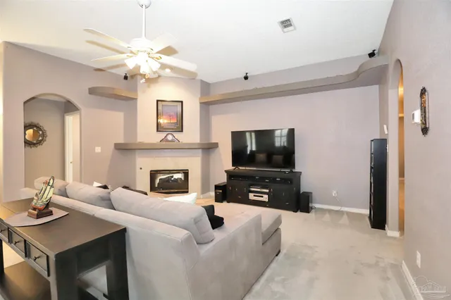 a living room with furniture a fireplace and a flat screen tv