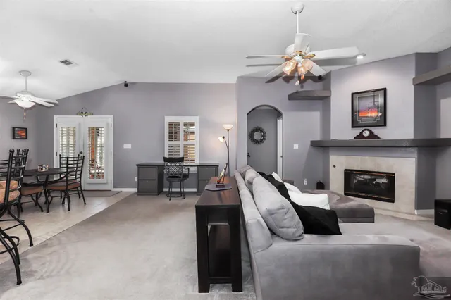 a living room with furniture a fireplace and chandelier