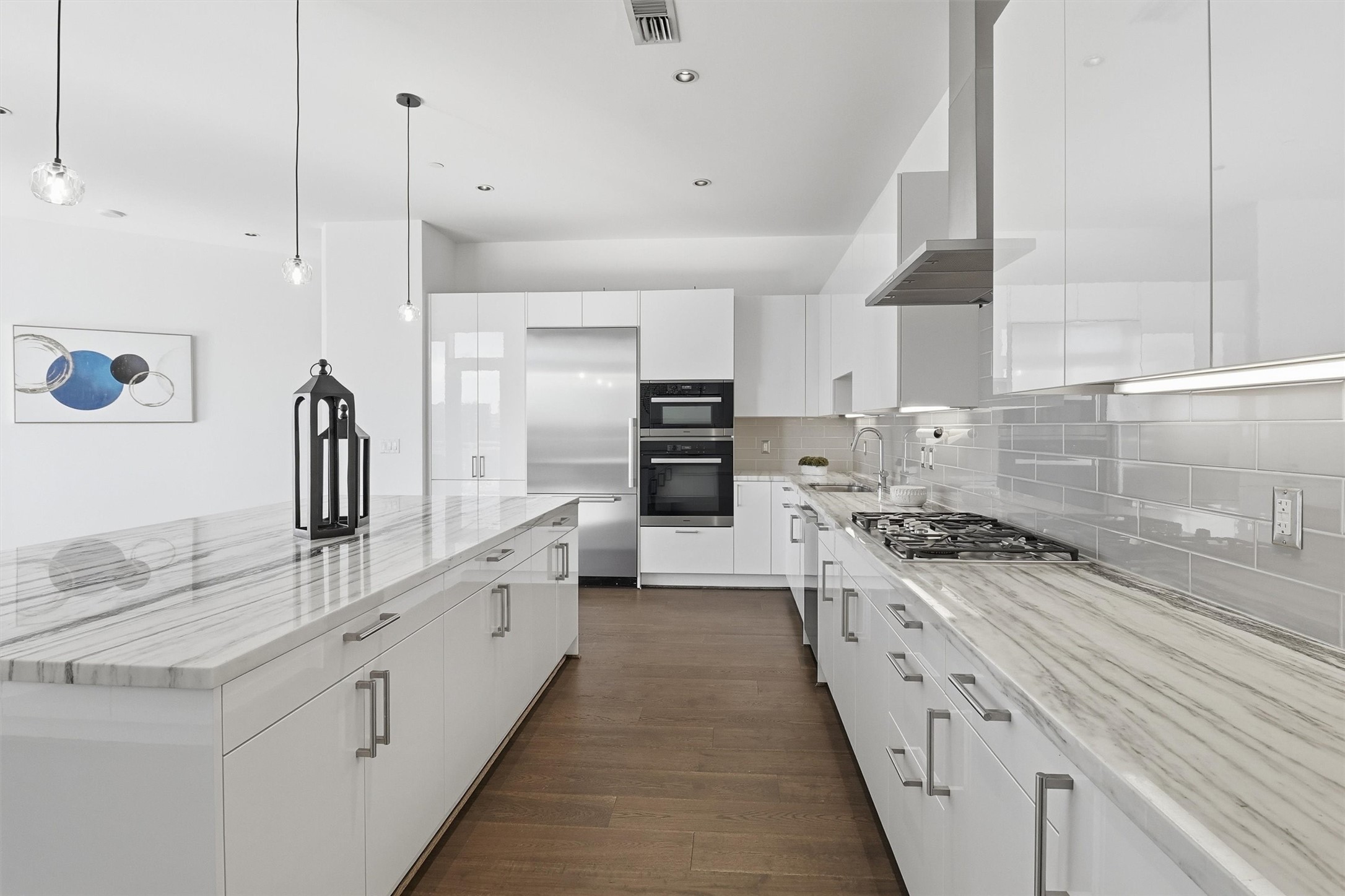 1409 Post Oak Boulevard, Unit 2004 Houston, TX 77056 - Photo 9 of 49 a large kitchen with kitchen island granite countertop a sink a counter space stainless steel appliances and cabinets