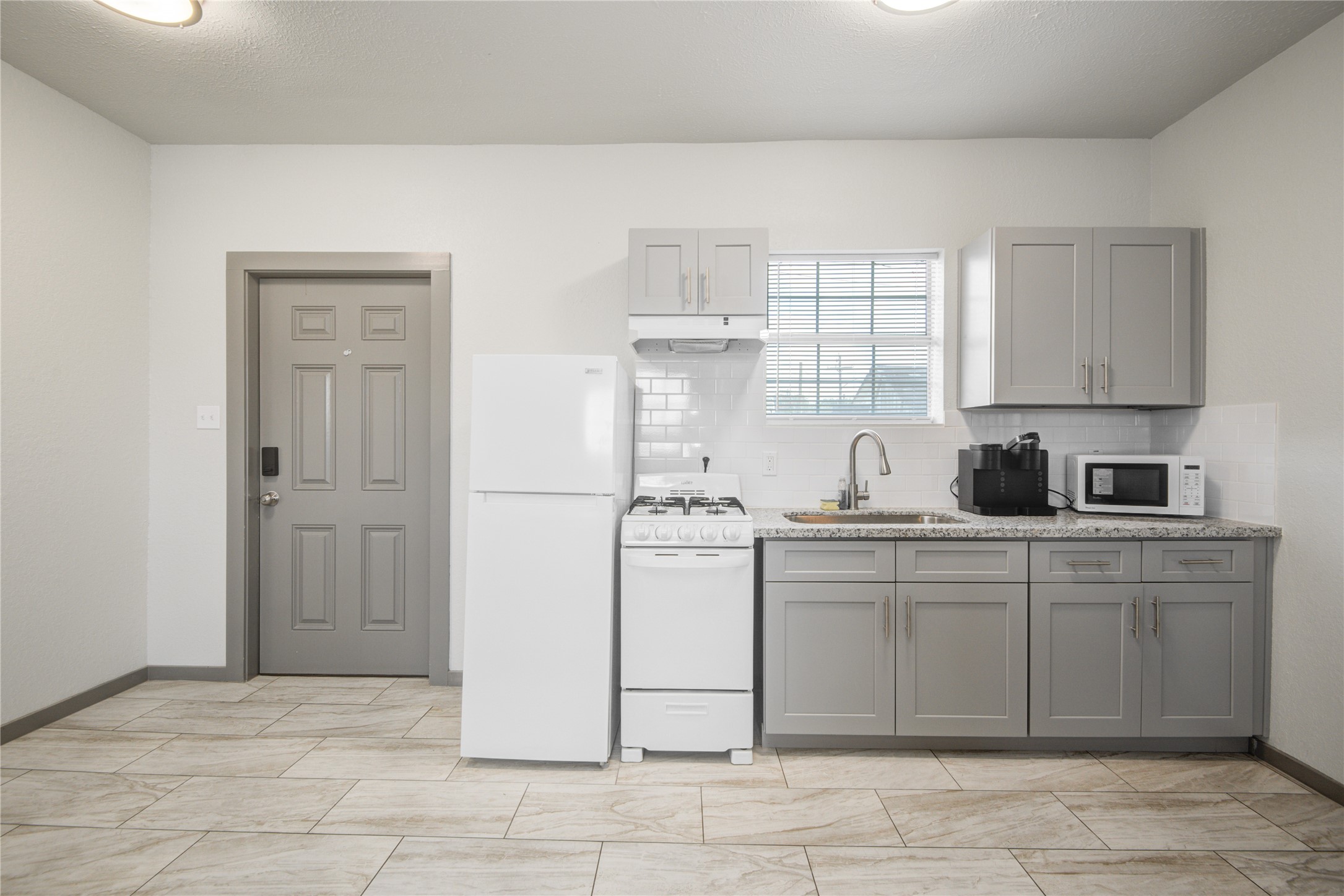 208 West 2nd Street Sweeny, TX 77480 - Photo 6 of 12 a kitchen with stainless steel appliances granite countertop a stove a sink and a refrigerator