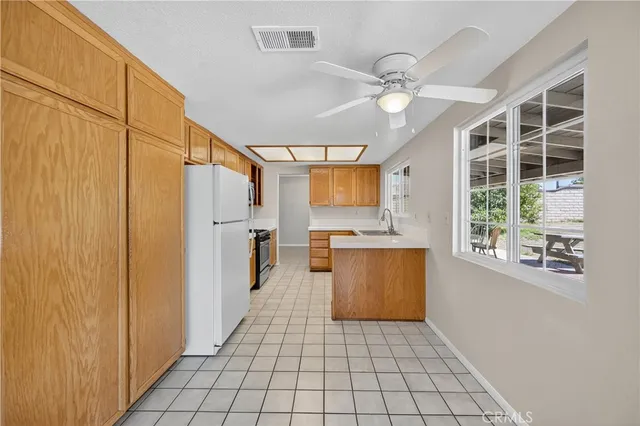 a large white kitchen with a sink dryer and cabinets