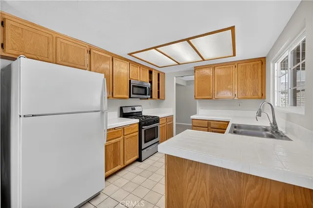 a kitchen with stainless steel appliances a refrigerator sink and microwave