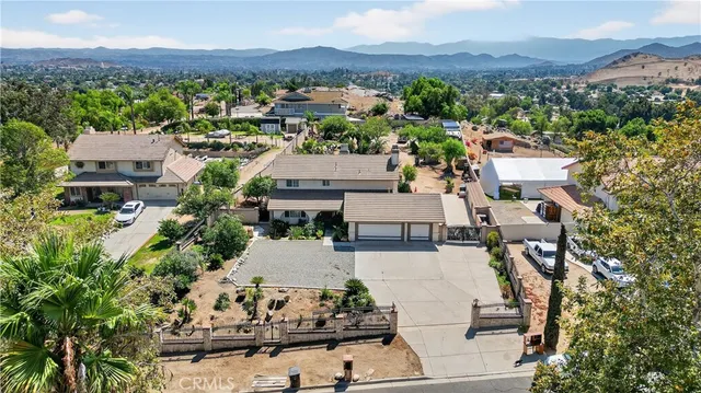 an aerial view of a house with a mountain