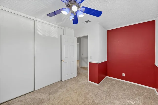 an empty room with windows and fan