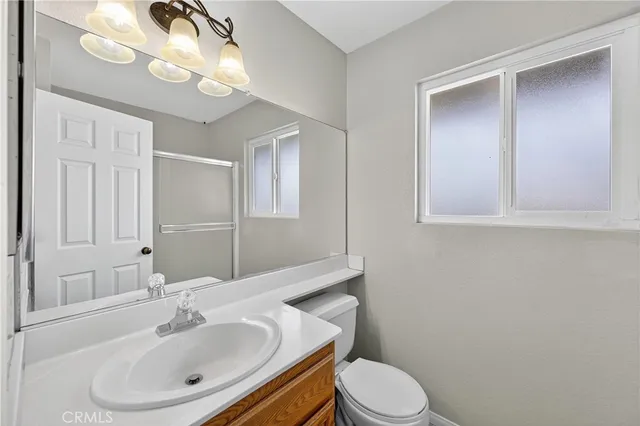 a bathroom with a sink vanity granite and toilet