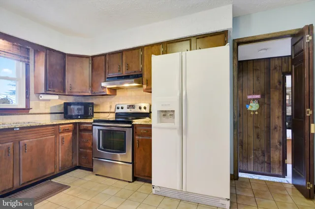 a kitchen with stainless steel appliances granite countertop a refrigerator and a sink