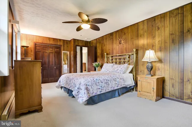 a bedroom with a bed dresser and a large mirror