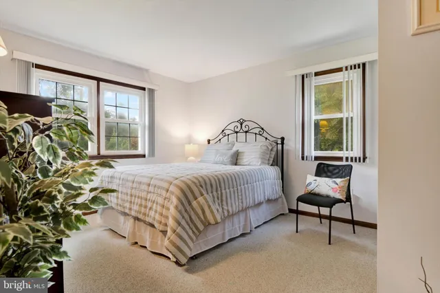 a bed sitting in a bedroom next to a window