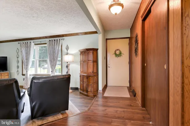 a view of a hallway with furniture and wooden floor