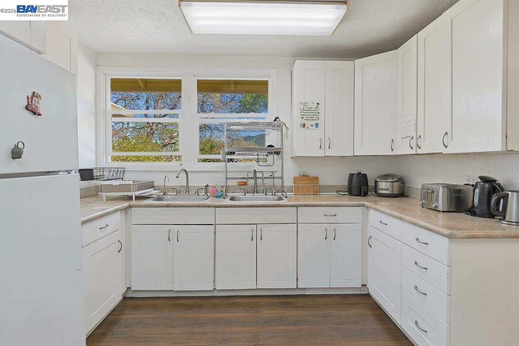 179 Los Ranchitos Road San Rafael, CA 94903 - Photo 4 of 38 a kitchen with granite countertop white cabinets and white appliances