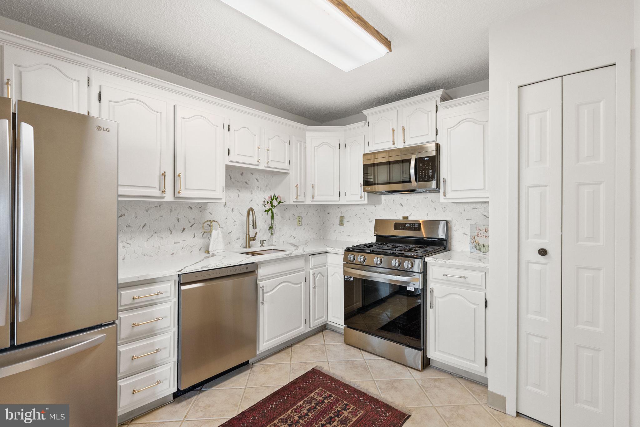 a kitchen with cabinets stainless steel appliances and a counter space