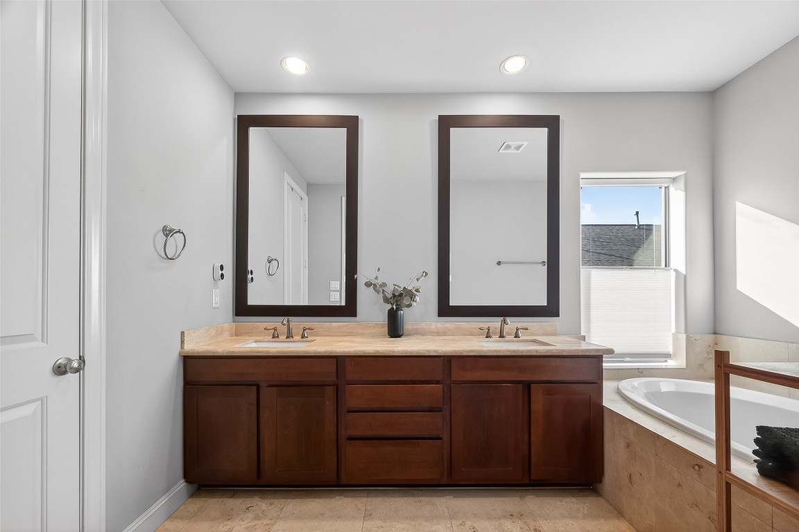 605 Meadow Street Houston, TX 77020 - Photo 25 of 31 a bathroom with double vanity sinks a large mirror and a bathtub