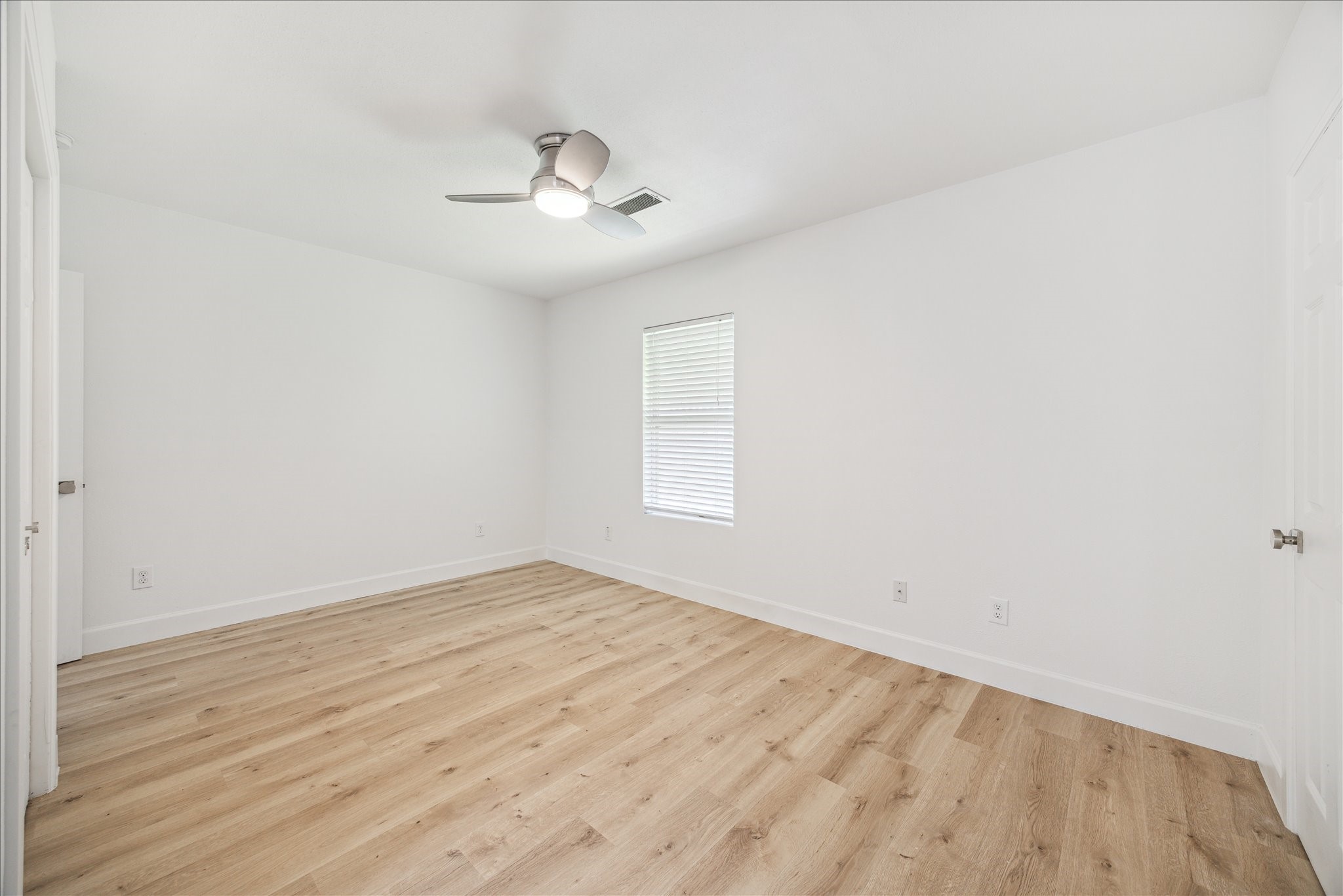 1419 Laird Street Houston, TX 77008 - Photo 13 of 15 an empty room with wooden floor fan and windows