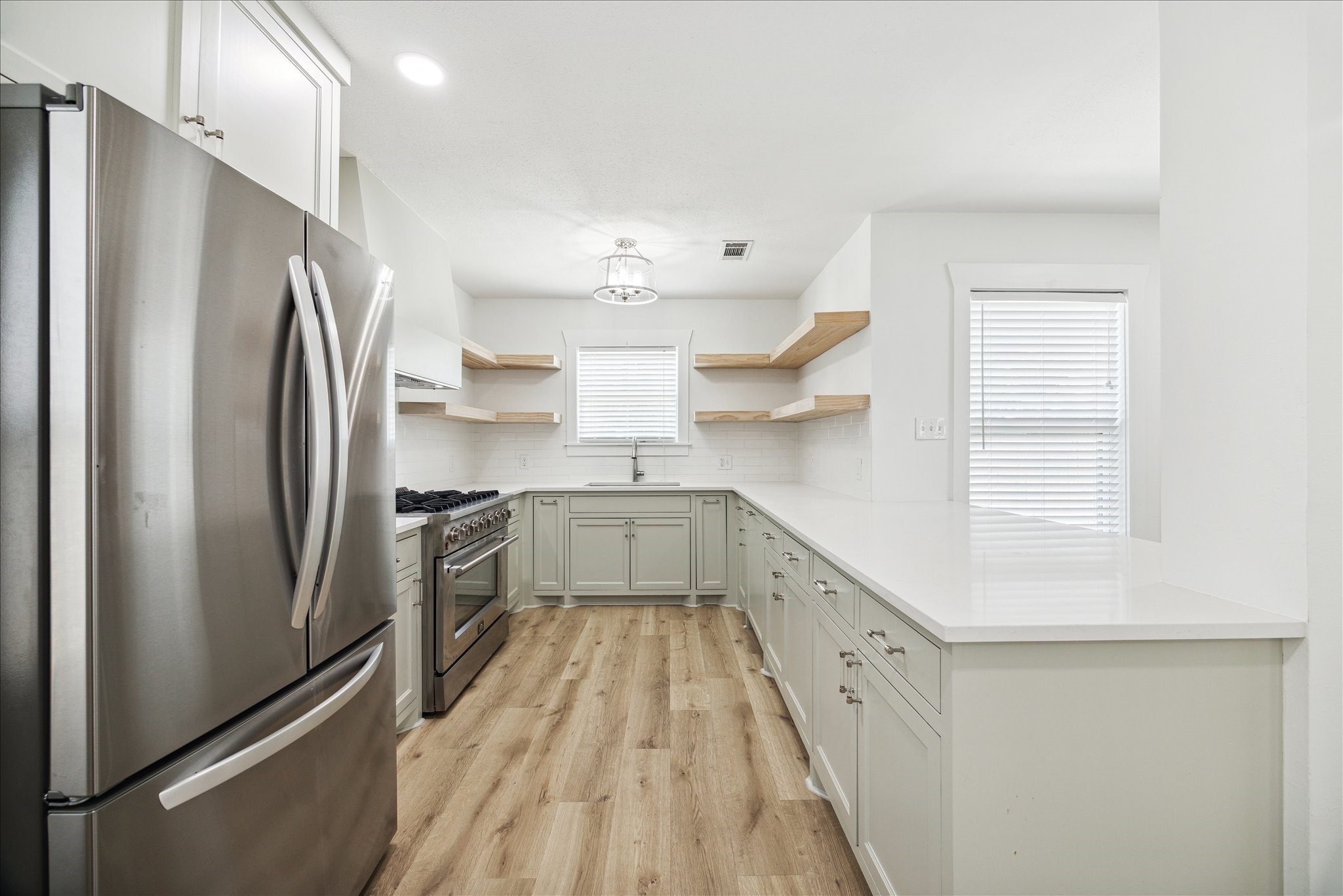 1419 Laird Street Houston, TX 77008 - Photo 5 of 15 a kitchen with stainless steel appliances a refrigerator sink and cabinets