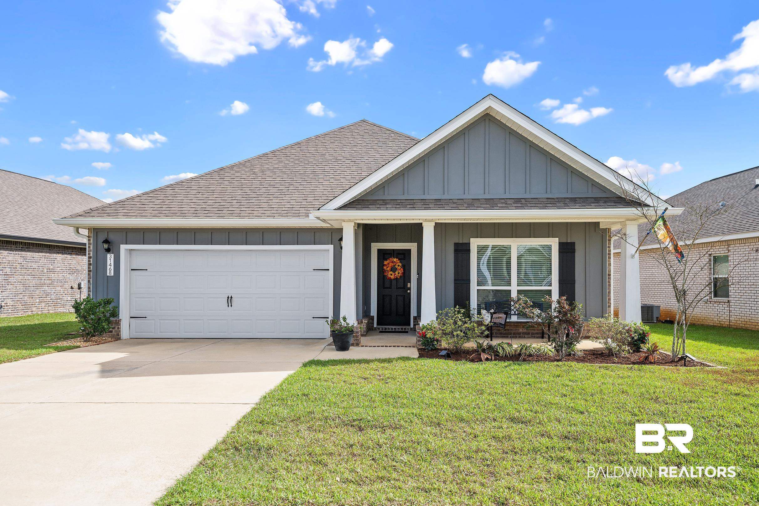 31468 Memphis Loop Daphne, AL 36527 - Photo 1 of 24 View of front facade with board and batten siding, covered porch, a shingled roof, driveway, and an attached garage