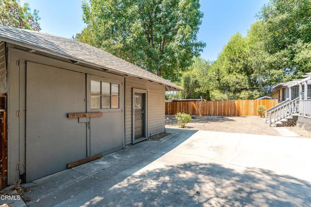 an aerial view of residential houses with outdoor space and trees