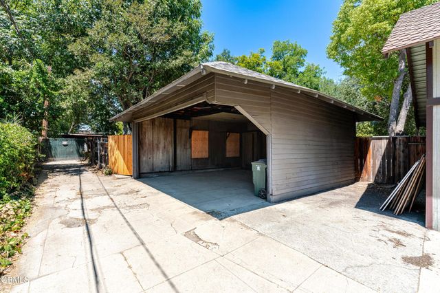 an aerial view of residential houses with outdoor space and trees all around