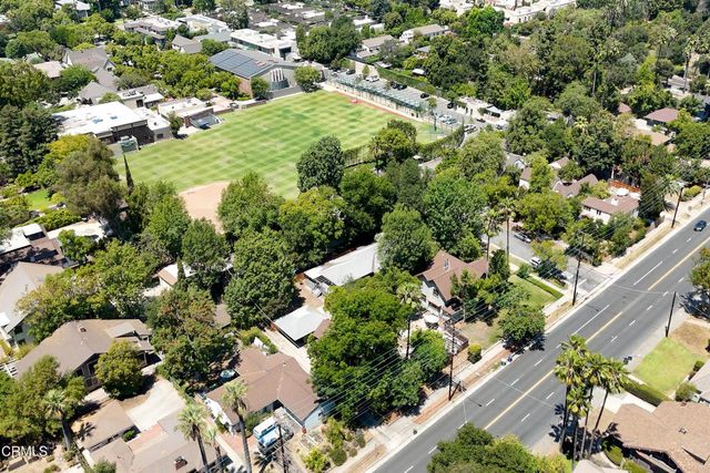an aerial view of residential houses with outdoor space and trees
