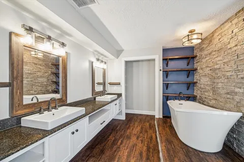 a bathroom with a sink a bathtub a mirror a vanity and a shower