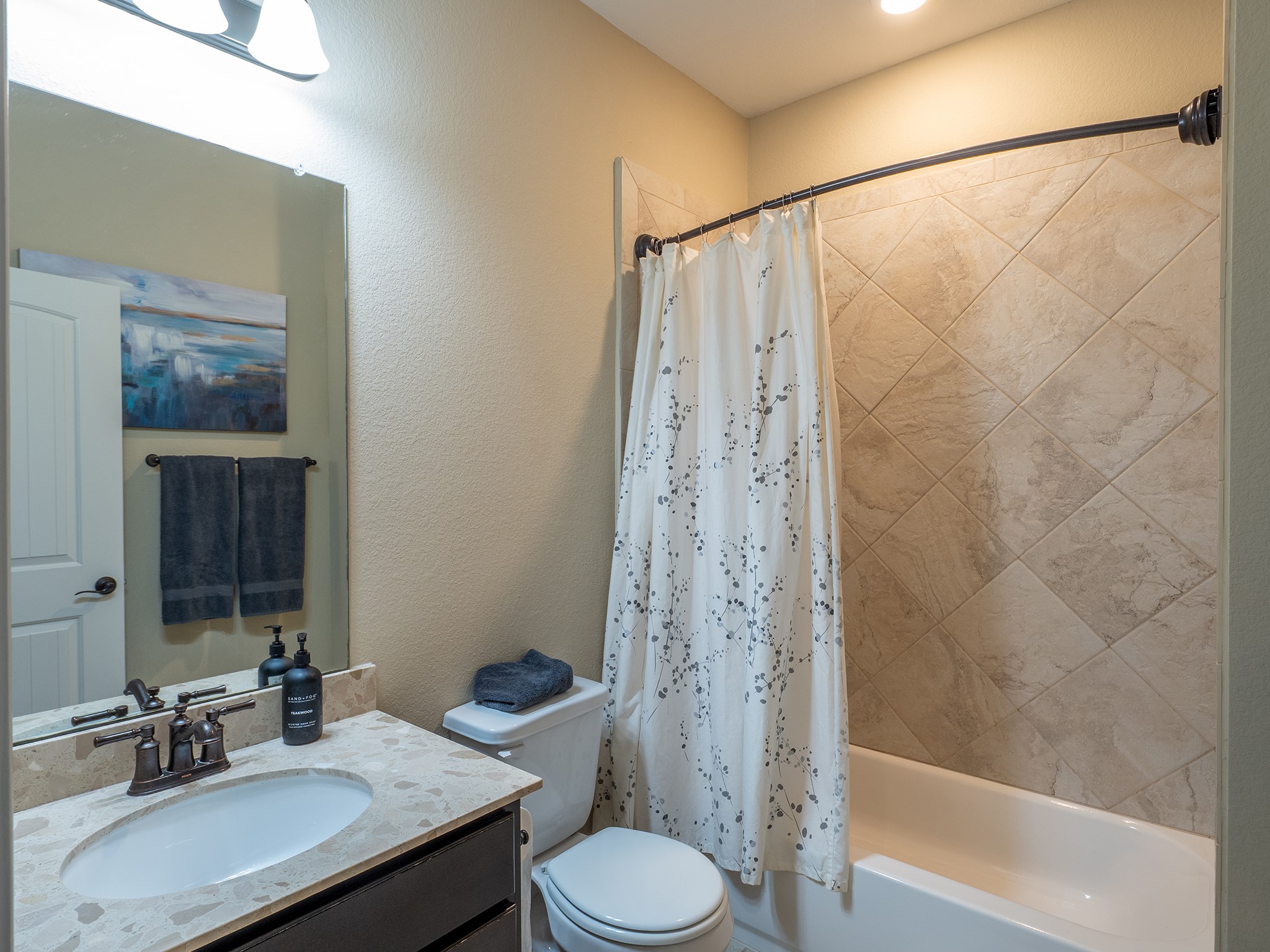 104 Rocroi Drive Georgetown, TX 78626 - Photo 27 of 40 A classic tub-and-shower combination is flanked by a stone-countertop vanity.