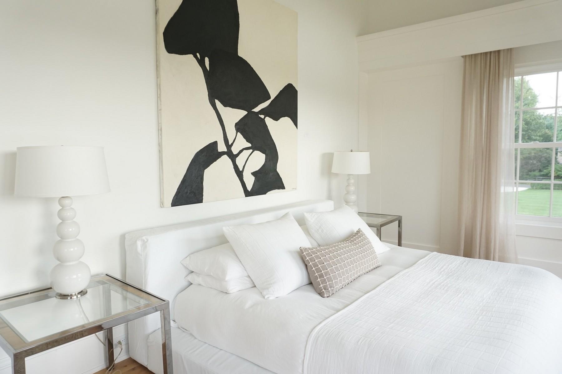 106 Pear Tree Point Road Darien, CT 06820 - Photo 20 of 43 a bedroom with a bed and a lamp next to a window