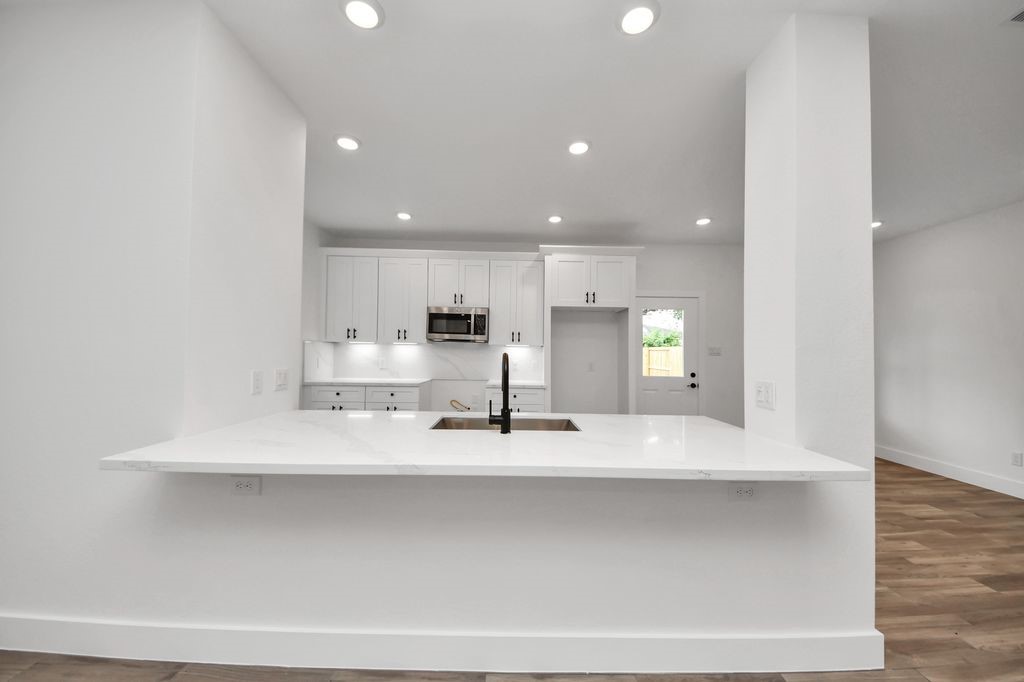 767 Marjorie Street Houston, TX 77088 - Photo 5 of 20 a large white kitchen with a sink and a microwave