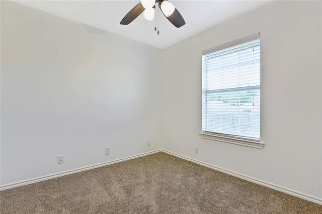 an empty room with closet and a chandelier fan