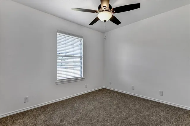 an empty room with chandelier fan
