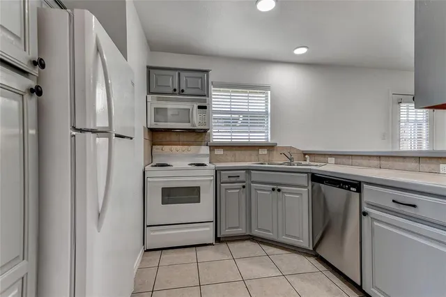 a kitchen with granite countertop cabinets stainless steel appliances and a sink