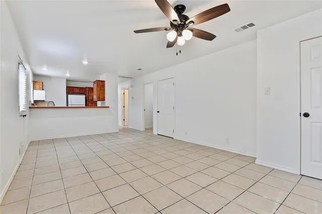 a view of a livingroom with a ceiling fan and window