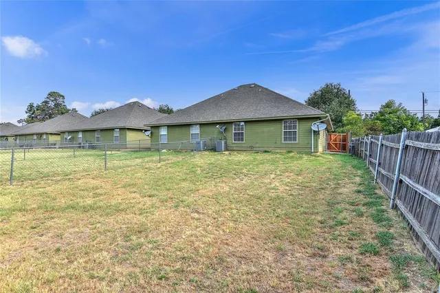 a view of a house with backyard and trees