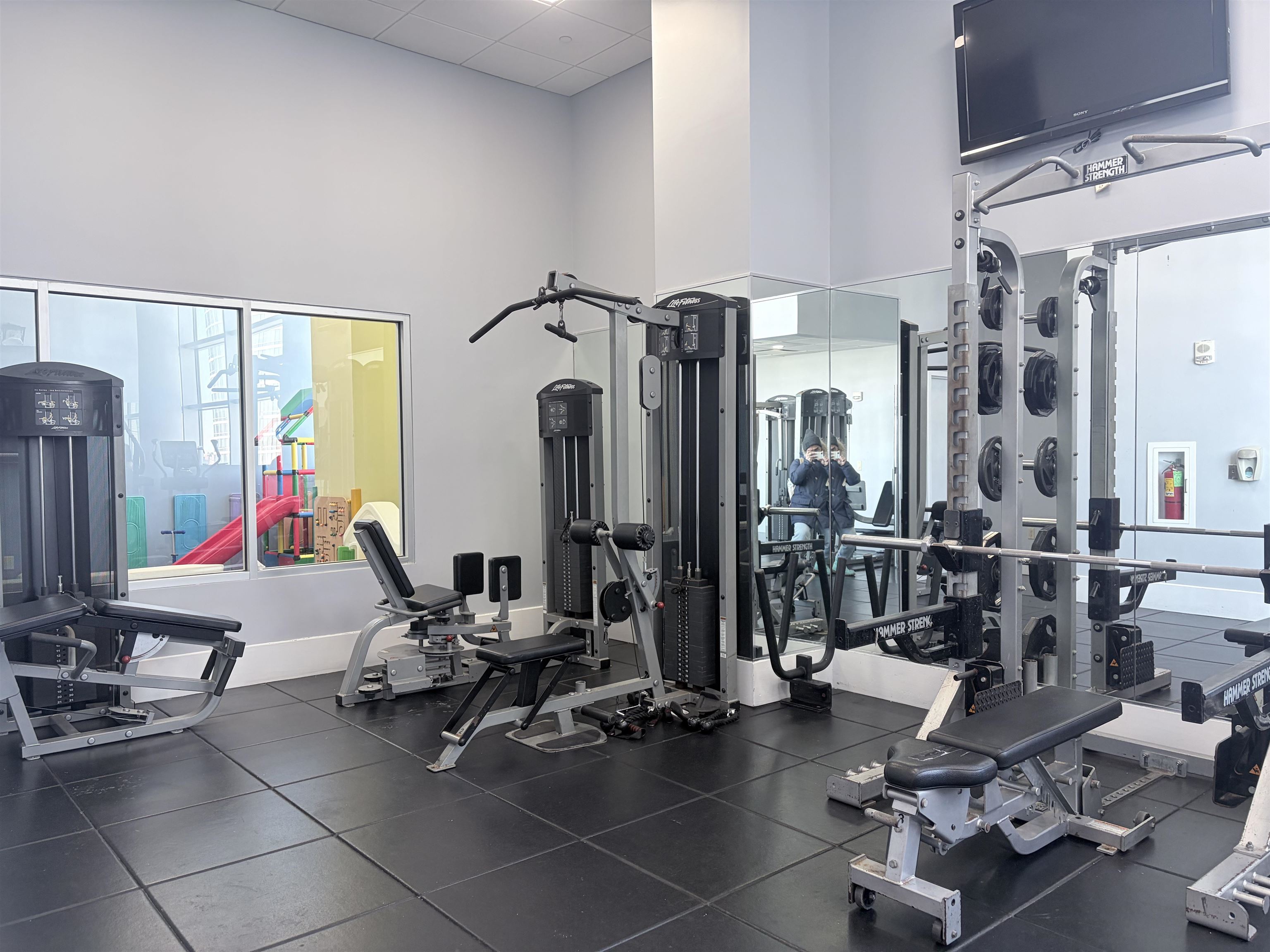 1 Shore Lane, Unit 1609 Jersey City, NJ 07310 - Photo 23 of 27 a room with gym equipment and large mirror