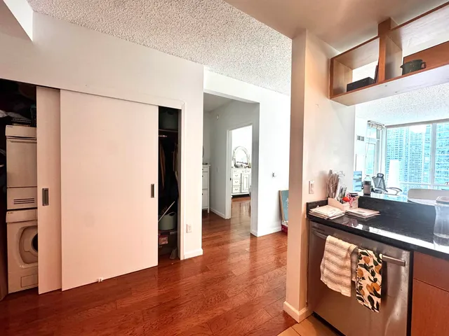 a living room with stainless steel appliances granite countertop furniture and a wooden floor