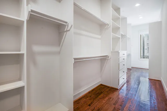 a view of walk in closet with wooden floor