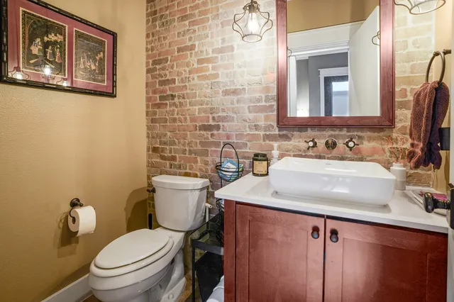 a bathroom with a granite countertop toilet sink and mirror
